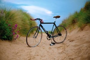 bicicleta aparcada en la arena para hablar del síndrome del ciclista o atrapamiento del nervio pudendo